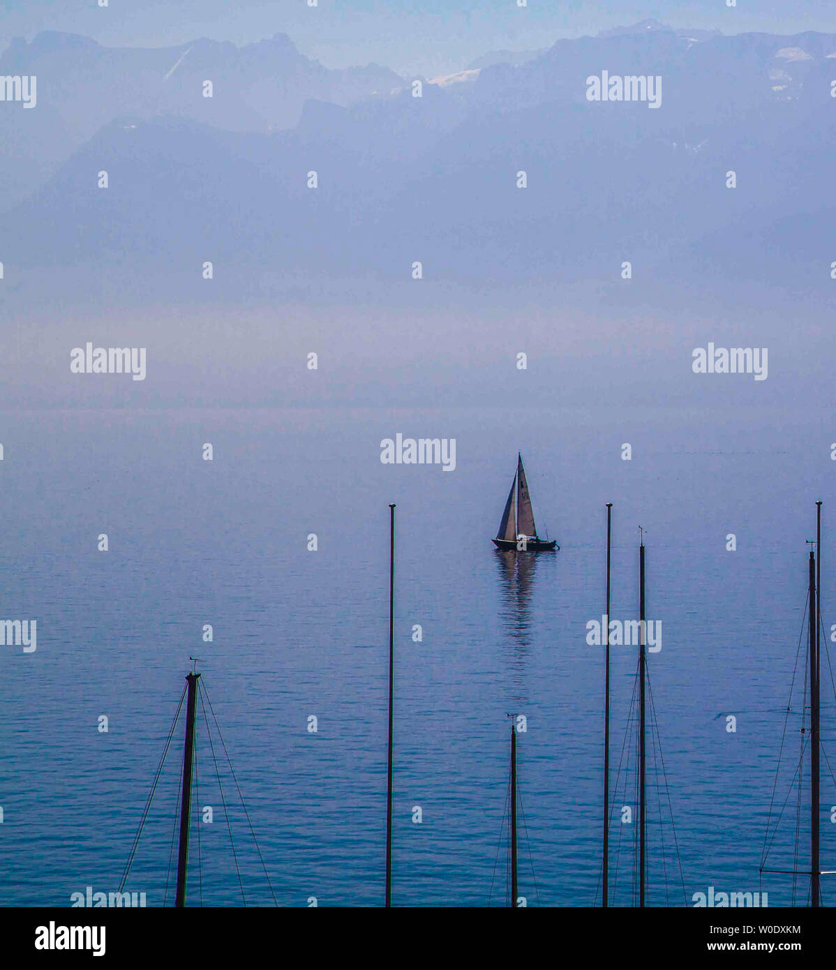 Bateau à voile sur le Lac Léman et les montagnes en arrière-plan Banque D'Images