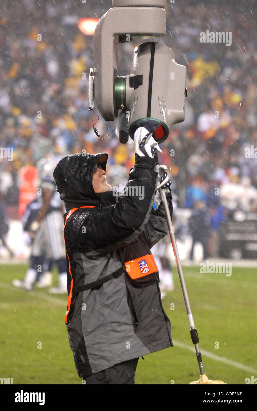 Un technicien Films NFL off nettoie les lese du ciel cam comme de fortes précipitations pendant la Redskins de Washington joue aux Cowboys de Dallas à FedEx Field à Landover, Maryland le 30 décembre 2007. (UPI Photo/Kevin Dietsch) Banque D'Images