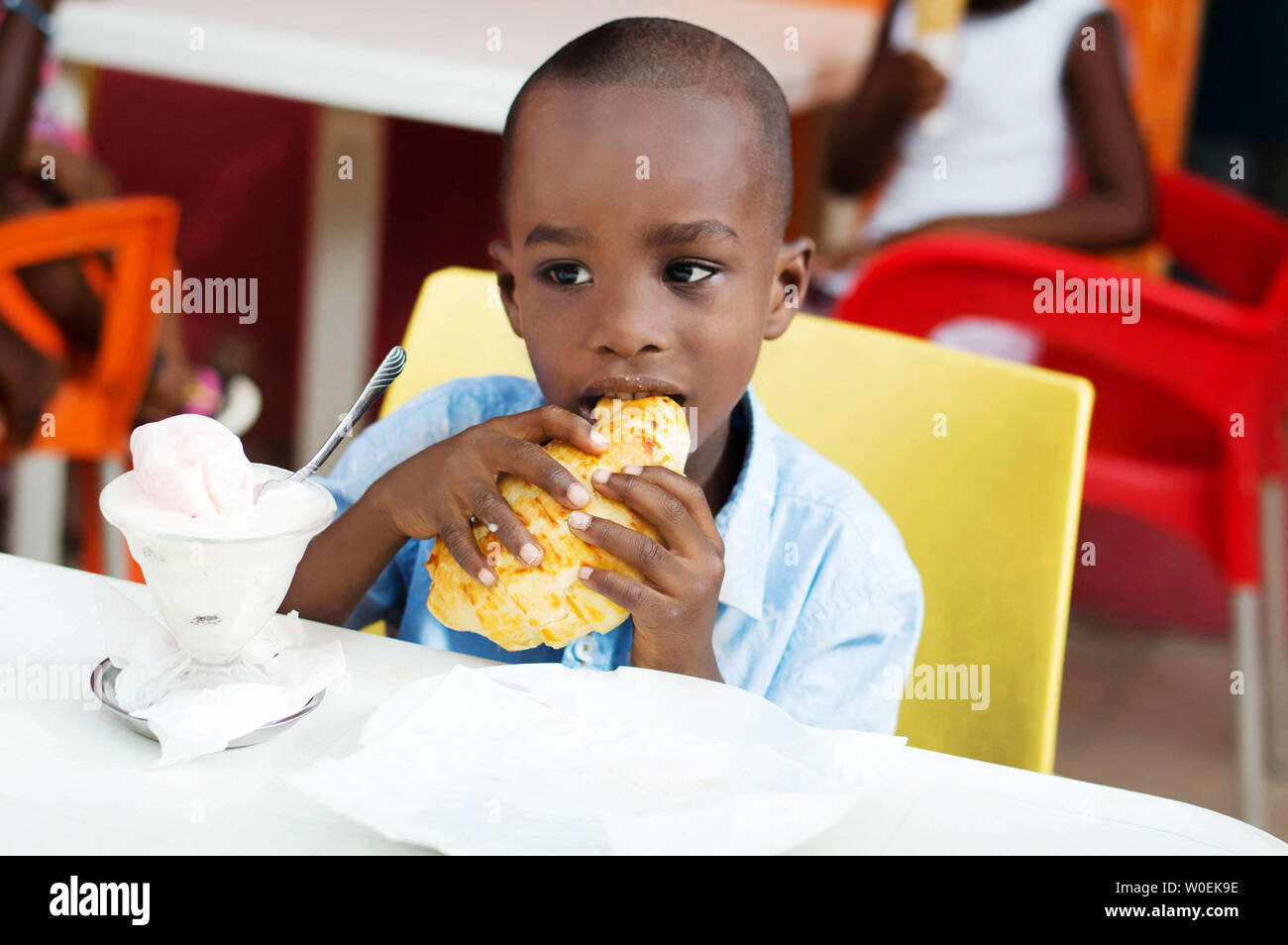 Enfant alla prendre son petit déjeuner avec ses parents au restaurant. Banque D'Images