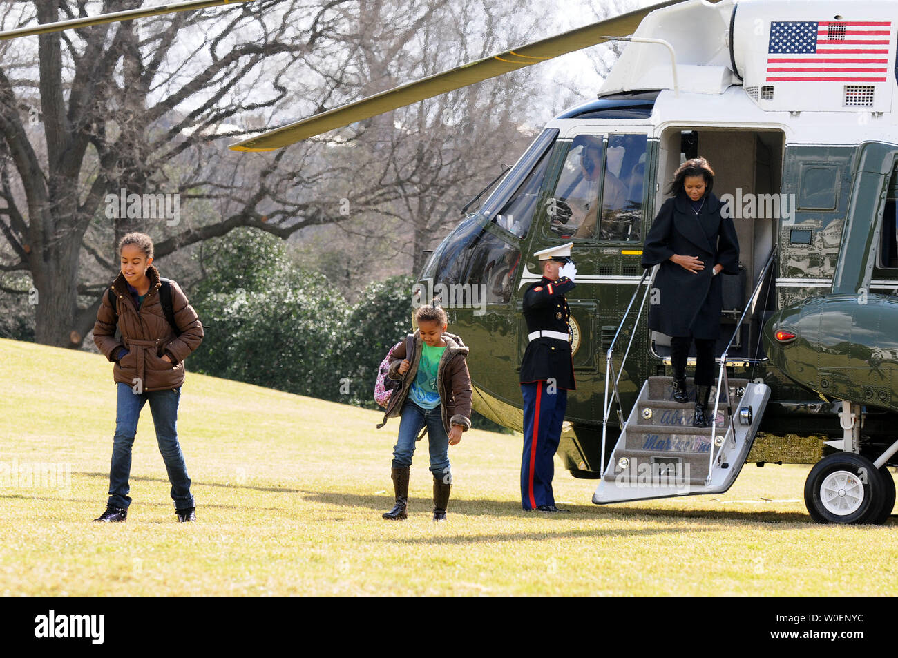 Le président Barack Obama's Daughters Malia (L),10, et Sasha, 7, suivi par leur mère, la Première Dame Michelle Obama, retour à la Maison Blanche après un week-end avec leurs parents à Chicago, sur la pelouse Sud de la Maison Blanche à Washington, le 16 février 2009. (UPI Photo/Kevin Dietsch) Banque D'Images