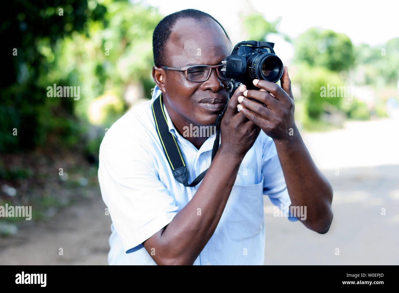 Les gens, photographie, animation et le mode de vie - heureux jeune homme tenant un appareil photo numérique et prendre des photos sur la rue de la campagne Banque D'Images