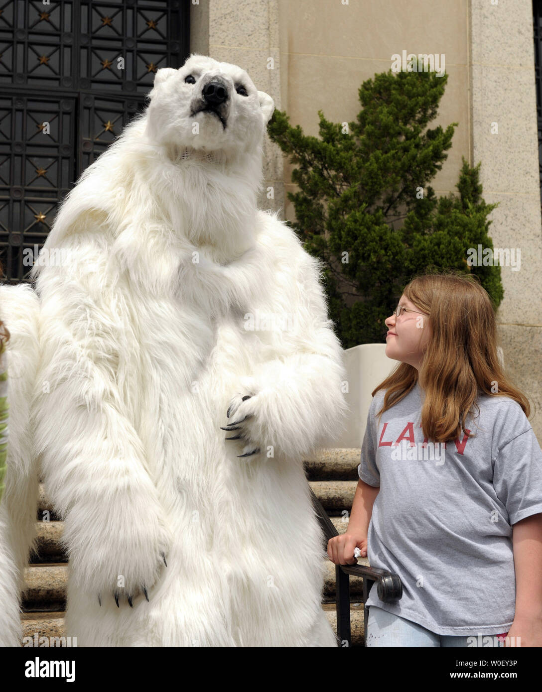 Un homme habillé en ours polaire se dresse avec Kate Muffett, 10 ans,  devant le Département de l'Intérieur à Washington le 7 mai 2009. L'ours a  rejoint les enfants de l'école la