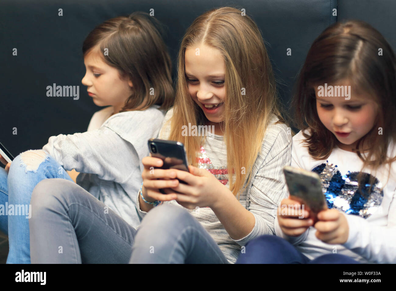3 filles avec smartphone Banque D'Images