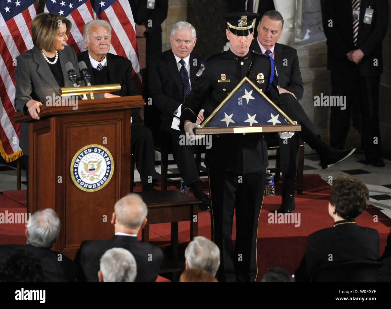 Un membre de la garde d'honneur est titulaire d'un drapeau américain à être présenté à Joyce Murtha, (inférieure,R), la veuve de feu le Rempl. John Murtha (D-PA), décédé le 8 février, à l'âge de 77l, à la capitale américaine le 3 mars 2010 à Washington. En arrière-plan (de gauche à droite) la présidente de la Chambre Nancy Pelosi (D-CA), Rép. C.W. Bill Young (R-FL), le secrétaire à la Défense Robert Gates et la conseillère à la sécurité nationale, le général James L. Jones. Murtha, un ancien officier du Corps des Marines, a été le premier vétéran de la guerre du Vietnam à être élu au Congrès, et plus tard est devenu un critique féroce de la guerre en Irak. UPI/Mike Theiler Banque D'Images