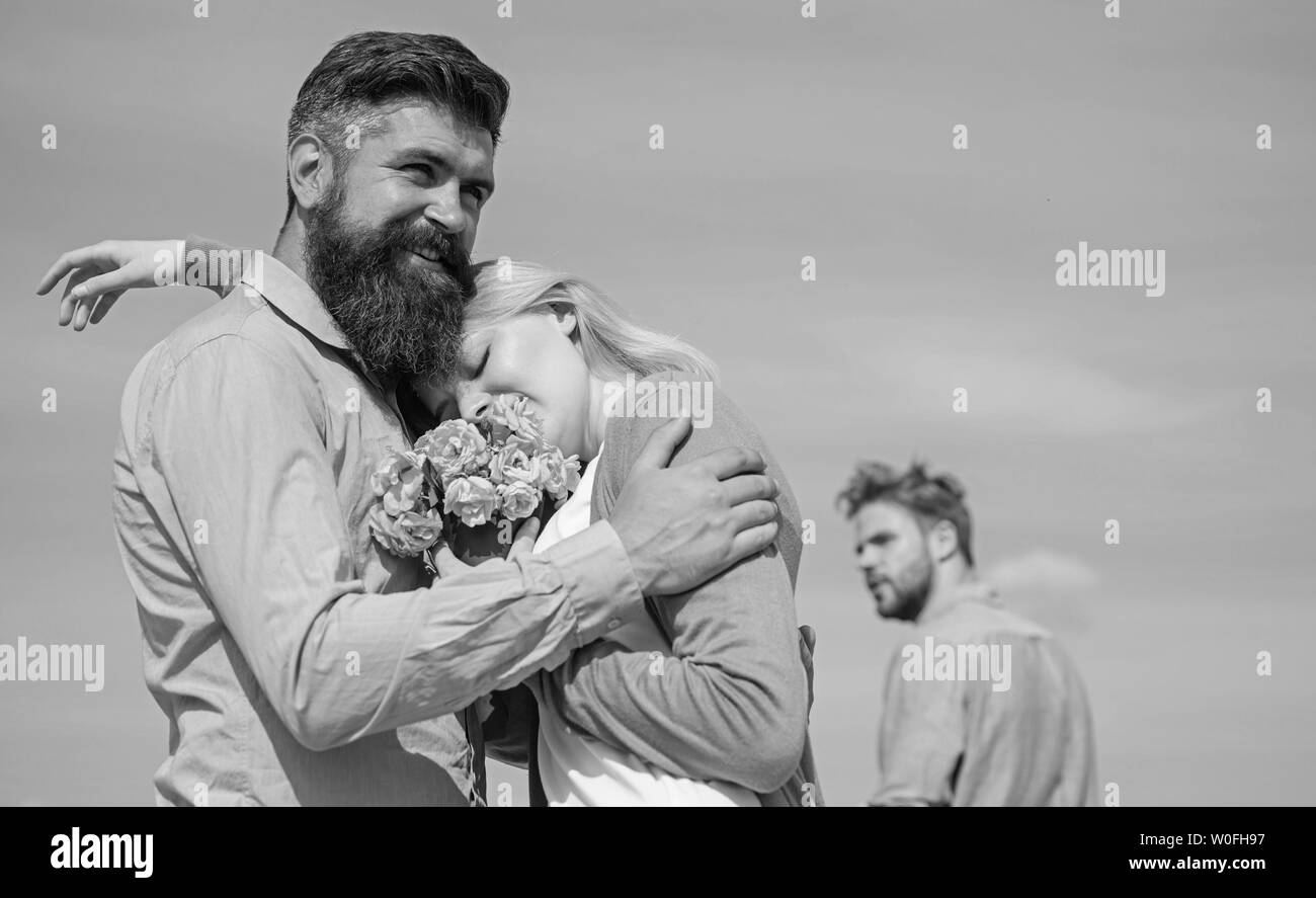 Couple avec bouquet date romantique. Ex mari jaloux sur l'arrière-plan. Couple in love dating une journée ensoleillée, le fond de ciel. Laisser passé derrière. Ex-partenaire fille commence à regarder les relations amour heureux. Banque D'Images