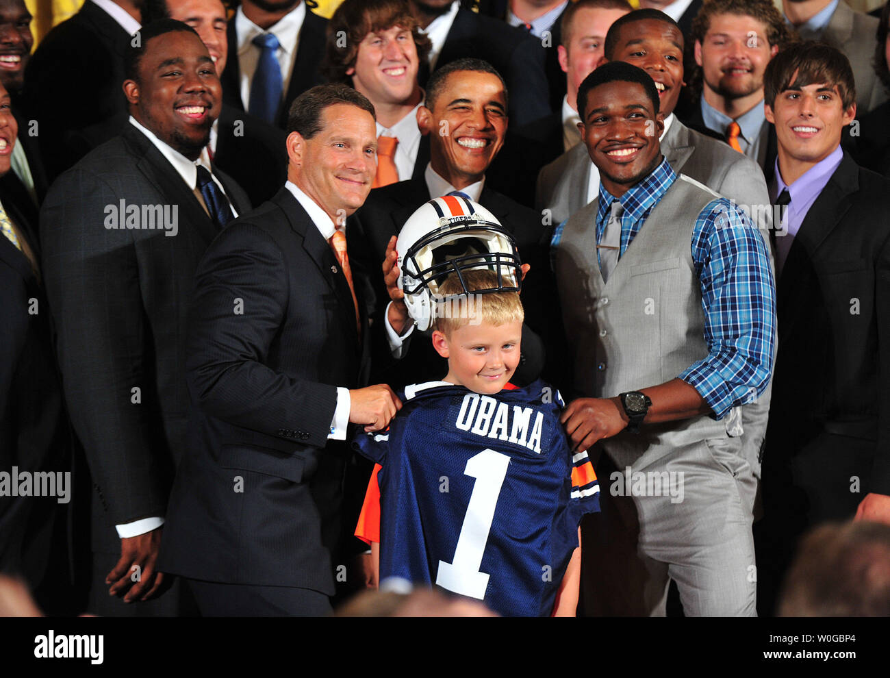 Le président Barack Obama met un casque sur la tête d'Ethan Gibbs, le fils de l'ancien secrétaire de presse Robert Gibbs, en tant que coach d'Auburn et Chizik gène récepteur large Kodi Burns brandis un jersey au cours d'une cérémonie en l'honneur du champion de la NCAA 2010 Auburn Tigers dans l'Est à la Maison Blanche à Washington le 8 juin 2011. UPI/Kevin Dietsch Banque D'Images