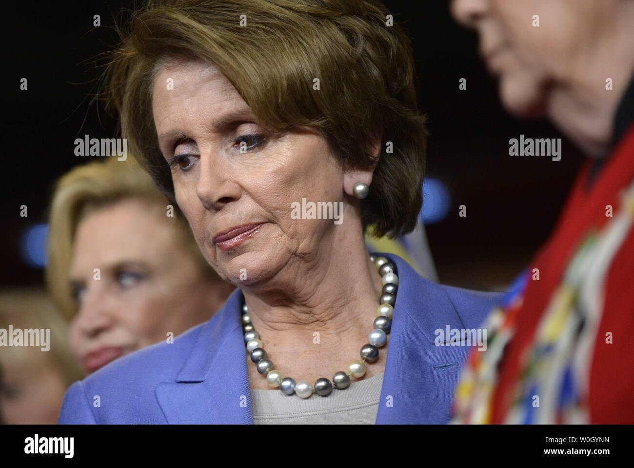 Chef de la minorité de la Chambre Nancy Pelosi (D-CA) est à l'écoute en tant que collègues démocrates de raconter des anecdotes de la violence par arme à feu lors d'une conférence de presse Le nouveau projet de loi présenté à la Chambre des représentants à grande capacité de bande de munitions de magazines, sur la colline du Capitole à Washington, DC Le 19 décembre 2012. Le projet de loi limiterait les clips pour un maximum de 10 balles et est une réponse à la récente prise de masse jusqu'à ces dernières années. UPI/Kevin Dietsch Banque D'Images