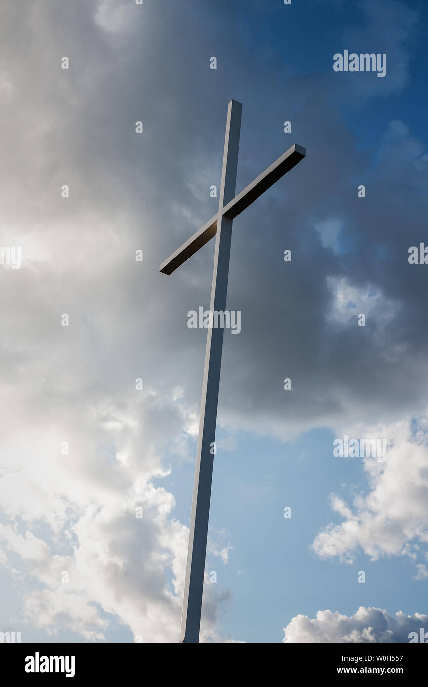 Grande croix métallique avec ciel bleu et nuages blancs à l'arrière-plan Banque D'Images