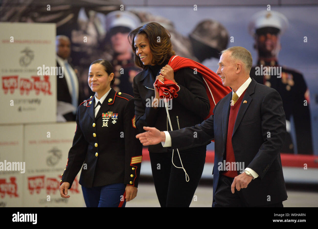 La Première Dame Michelle Obama, président-directeur général de Toys for Tots Ret. Marine Corps, le général Peter Osman et de l'USMC Le s.. Catalina Perez arrivent pour aider à trier les dons de jouets pour les jouets pour les tout-petits au cours d'un événement don at Joint Base Anacostia-Bolling à Washington, D.C. le 19 décembre 2013. La Première Dame a aidé à trier les dons, a salué les familles militaires et livrés de don de jouets donnés par le personnel de la Maison Blanche. UPI/Kevin Dietsch Banque D'Images