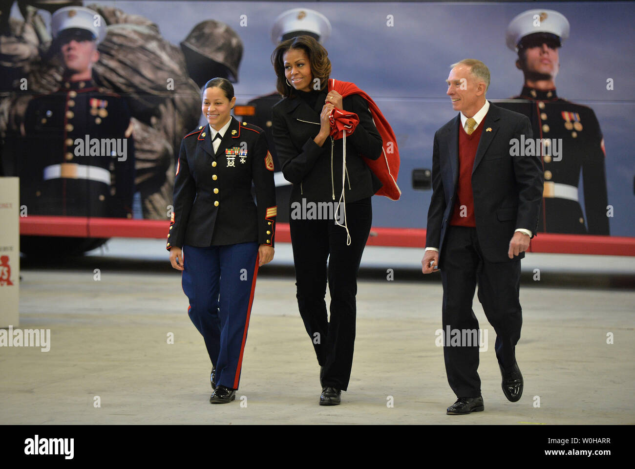 La Première Dame Michelle Obama, président-directeur général de Toys for Tots Ret. Marine Corps, le général Peter Osman et de l'USMC Le s.. Catalina Perez arrivent pour aider à trier les dons de jouets pour les jouets pour les tout-petits au cours d'un événement don at Joint Base Anacostia-Bolling à Washington, D.C. le 19 décembre 2013. La Première Dame a aidé à trier les dons, a salué les familles militaires et livrés de don de jouets donnés par le personnel de la Maison Blanche. UPI/Kevin Dietsch Banque D'Images