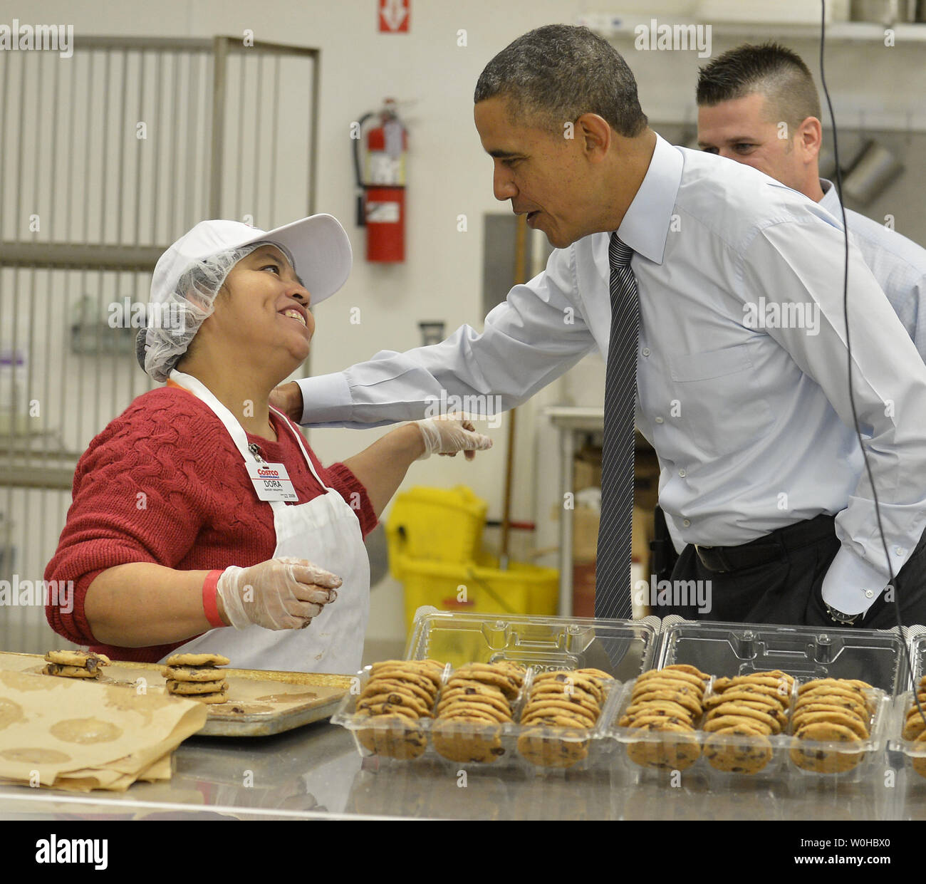 Le président américain Barack Obama (R) accueille un employé de boulangerie Costco comme il visite le magasin avant d'exécution remarques dans un magasin rally, comme il prend son état de l'Union sur une visite de deux jours à l'extérieur de Washington, à Lanham, Maryland, le 29 janvier 2014. Obama pousse le Congrès à élever le salaire minimum fédéral dans le cadre de son plan économique. UPI/Mike Theiler Banque D'Images
