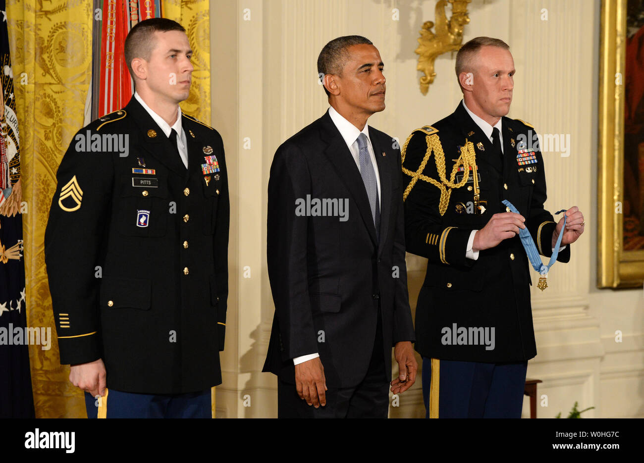 Le président américain, Barack Obama (C) est à l'écoute de la proclamation comme il s'apprête à présenter la Médaille d'honneur de l'ancien Sergent Ryan Pitts (L) au cours d'une cérémonie dans la East Room de la Maison Blanche le 21 juillet 2014. Pitts, du 2e peloton, compagnie choisie, 2e Bataillon (Airborne), 503e Régiment d'infanterie, 173e Brigade aéroportée, a reçu la plus haute distinction militaire pour ses actions courageuses au cours d'opérations de combat à la base de patrouille de Kahler dans la province de Kunar, de l'Afghanistan le 13 juillet 2008. UPI/Pat Benic Banque D'Images