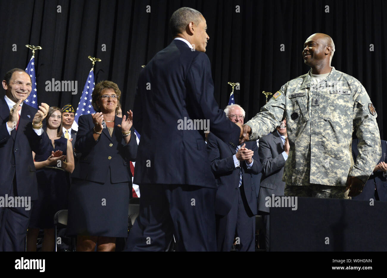 Le président américain, Barack Obama (C), serre la main avec le sergent de l'armée américaine. Le Major James McGruder, comme Anciens Combattants Secrétaire Robert McDonald (L) se réjouit de la signature d'Obama avant 3230, RH L'accès aux soins des anciens combattants par choix, la responsabilité et la transparence de la loi 2014, le 7 août 2014, à Fort Belvoir, Virginie. Le projet de loi vise à aider les anciens combattants, les soins de la simplification de la bureaucratie de l'AV dans des domaines tels que les nominations et la formation du personnel et le personnel des établissements de soins médicaux. UPI/Mike Theiler Banque D'Images