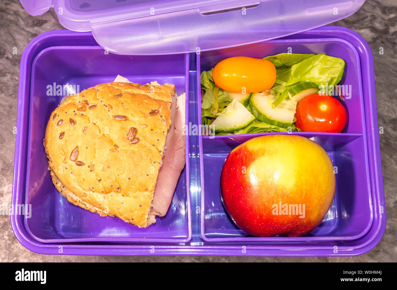 Libre passage tiré d'un pourpre d'un enfant le déjeuner fort, rempli d'un repas sain, de sandwich au jambon, salade et une pomme. Banque D'Images