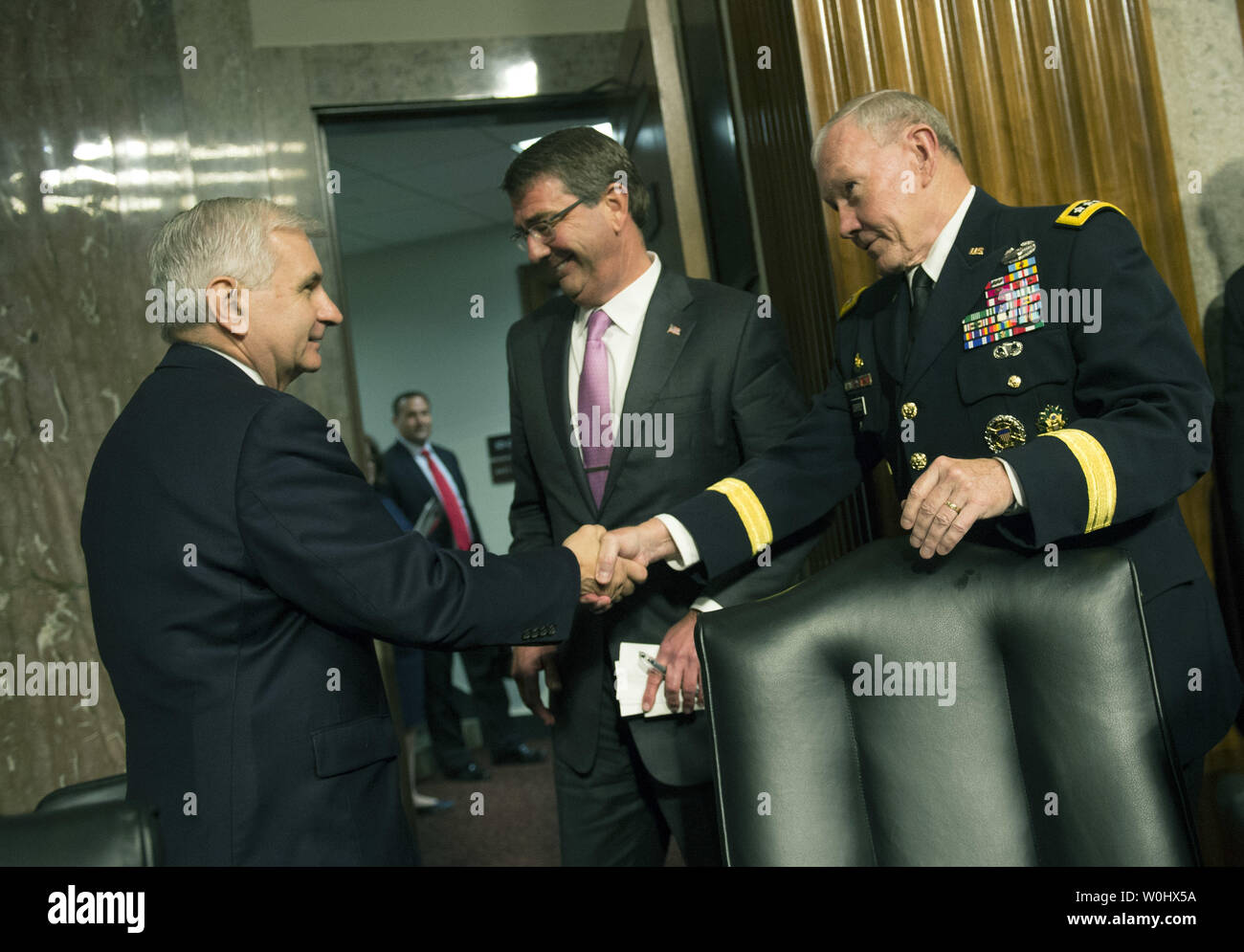 Secrétaire du Comité des chefs d'état-major général Martin Dempsey, serre la main avec le sénateur Jack Reed, D-ri, comme le secrétaire à la défense, Ashton Carter regardé après avoir témoigné lors d'une audience du Comité des forces armées du Sénat sur la campagne militaire contre l'État islamique, sur la colline du Capitole à Washington, D.C. le 7 juillet 2015. Photo par Kevin Dietsch/UPI Banque D'Images