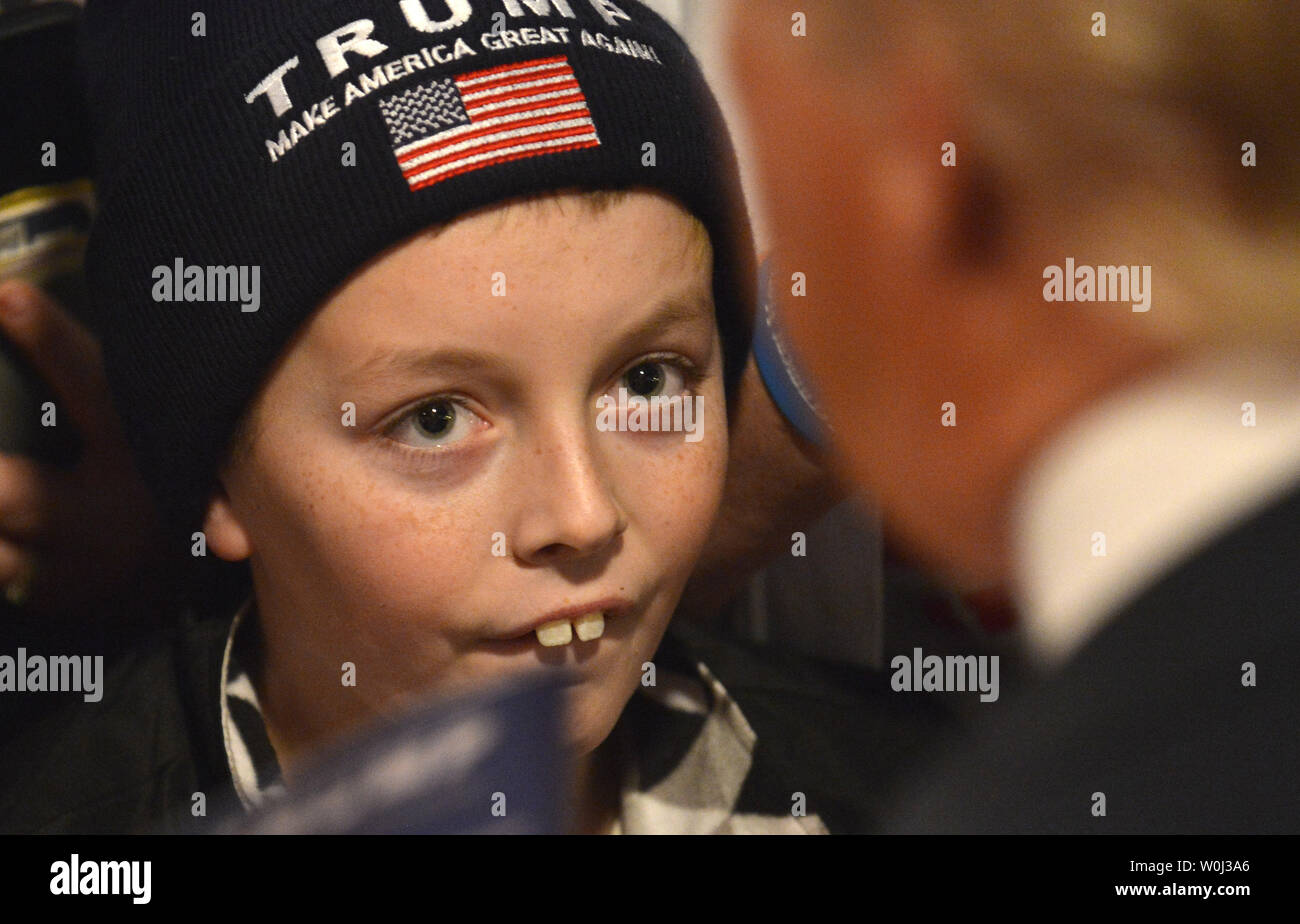 Un enfant avec un bouchon d'Atout regarde magnat de l'immobilier Donald J. Trump, 2016 candidat présidentiel républicain, comme il accueille les partisans à la Surf Ballroom, le 9 janvier 2016, dans la région de Clear Lake, Iowa. Trump est en marche contre un grand champ de candidats, y compris le Texas GOP Sen. Ted Cruz, Marco Rubio en Floride Sen. et retraités Ben Carson, neurochirurgien de l'avant première de l'Iowa-dans-le-nation 1. Février caucus Photo de Mike Theiler/UPI Banque D'Images