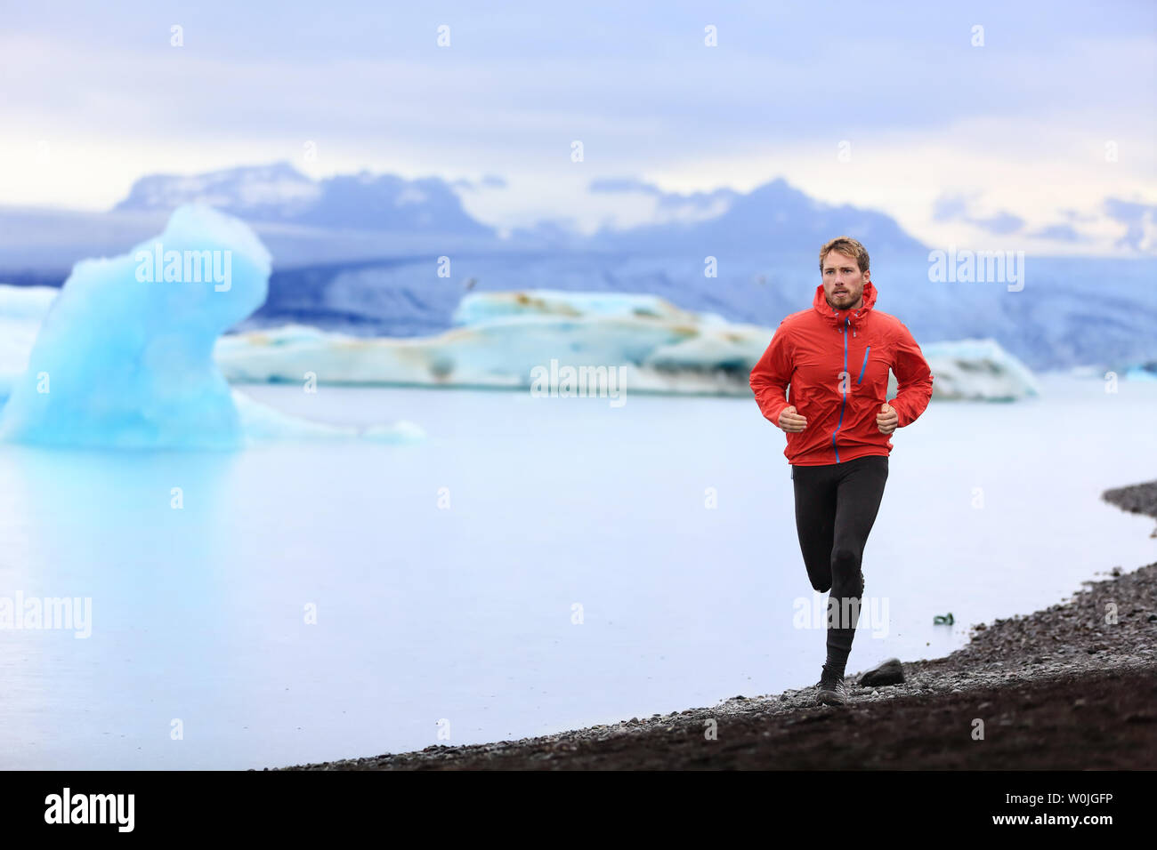 Homme courant. Trail Runner pour formation de marathon dans le magnifique paysage naturel. Mettre en place de l'athlète masculin le jogging et course cross-country par les icebergs Jokulsarlon Glacial lake en Islande. Banque D'Images