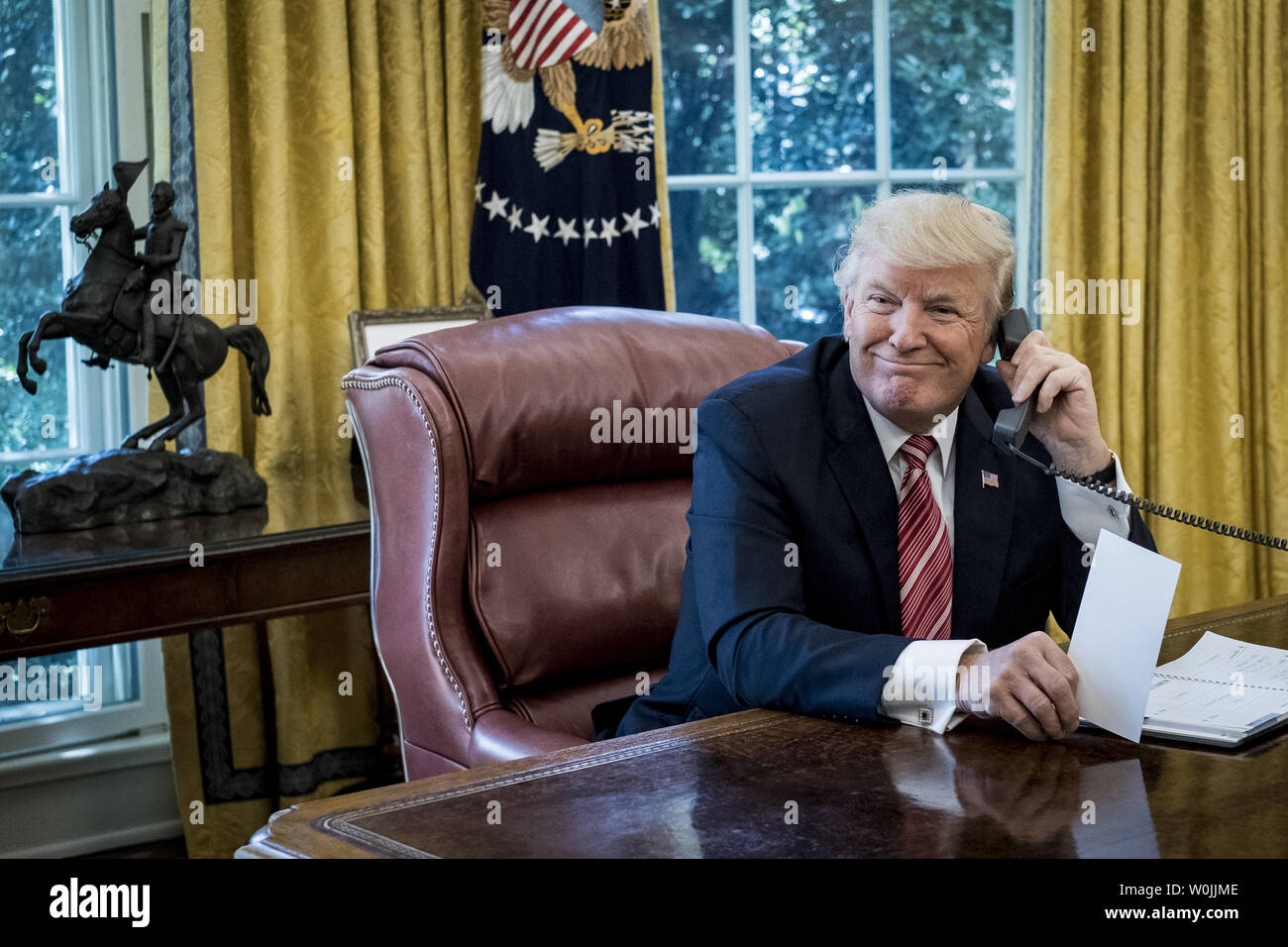 Le président Donald Trump sourit aux médias qu'il attend pour parler avec le premier ministre Leo Varadkar de l'Irlande par téléphone dans le bureau ovale à la Maison Blanche le 27 juin 2017 à Washington, DC. Trump a fait l'appel pour féliciter le nouveau premier ministre et actuel premier ministre. Le chef du Fine Gael, le Parti Varadkar a été élu à la suite du départ à la retraite d'Enda Kenny. Photo par Pete Marovich/UPI Banque D'Images
