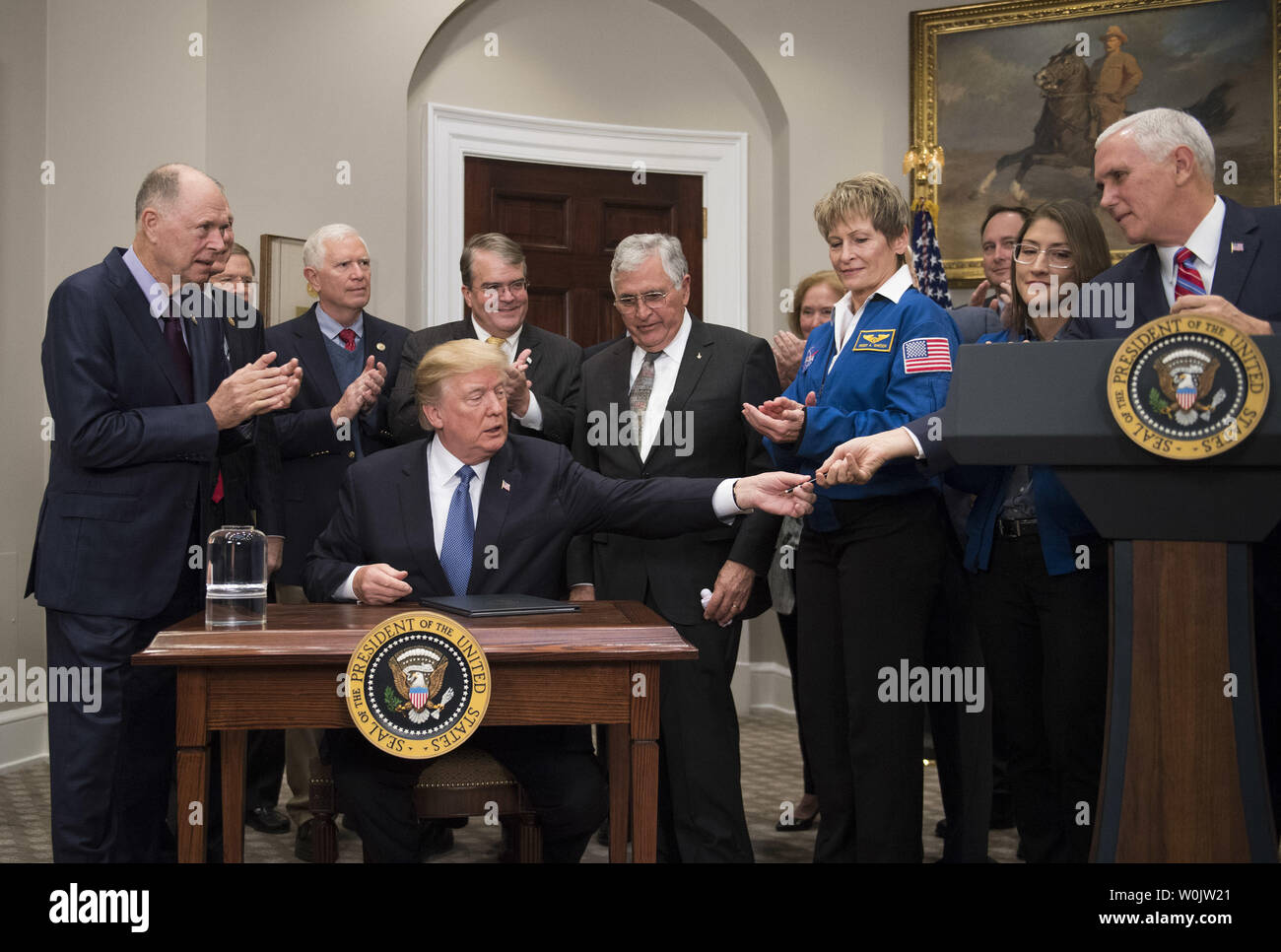Le président Donald Trump donne un stylo pour vice-président Mike pence l'espace politique Directive 1 signes, dans la Roosevelt Room à la Maison Blanche le 11 décembre 2017 à Washington, D.C. La directive assigne la NASA d'ouvrir un espace pour revenir en arrière les astronautes américains sur la Lune et, éventuellement, sur Mars. Trump a été rejoint par les membres du Conseil Espace, les astronautes et les membres du Congrès. Photo par Kevin Dietsch/UPI Banque D'Images