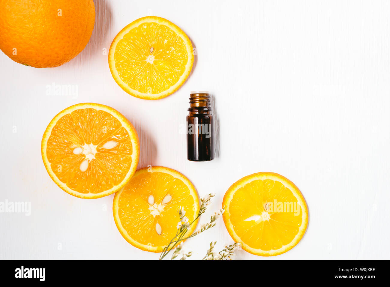 Bouteille de l'huile essentielle d'orange sur fond blanc pour la beauté, soins de la peau, bien-être et à des fins médicinales. Mise à plat. Banque D'Images