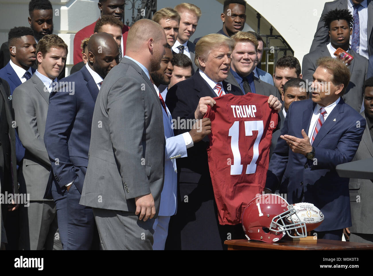 Le président Donald Trump (C) nous tend un jersey présenté par l'entraîneur en chef Nick Saban (R) et les joueurs de la NCAA National Champion Crimson Tide de l'équipe de football lors d'une visite à la Maison Blanche, le 10 avril 2018, à Washington, DC. Photo de Mike Theiler/UPI Banque D'Images