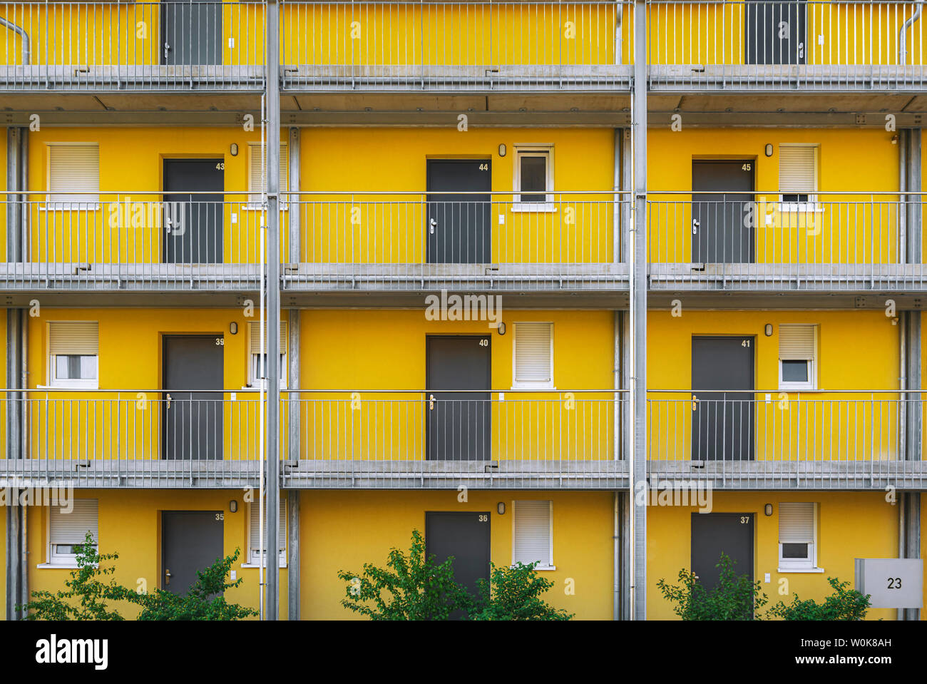 Appartement moderne d'extérieur de bâtiment avec des murs peints en jaune et gris, portes dans un quartier résidentiel dans la région de Schwabisch Hall, en Allemagne. Banque D'Images