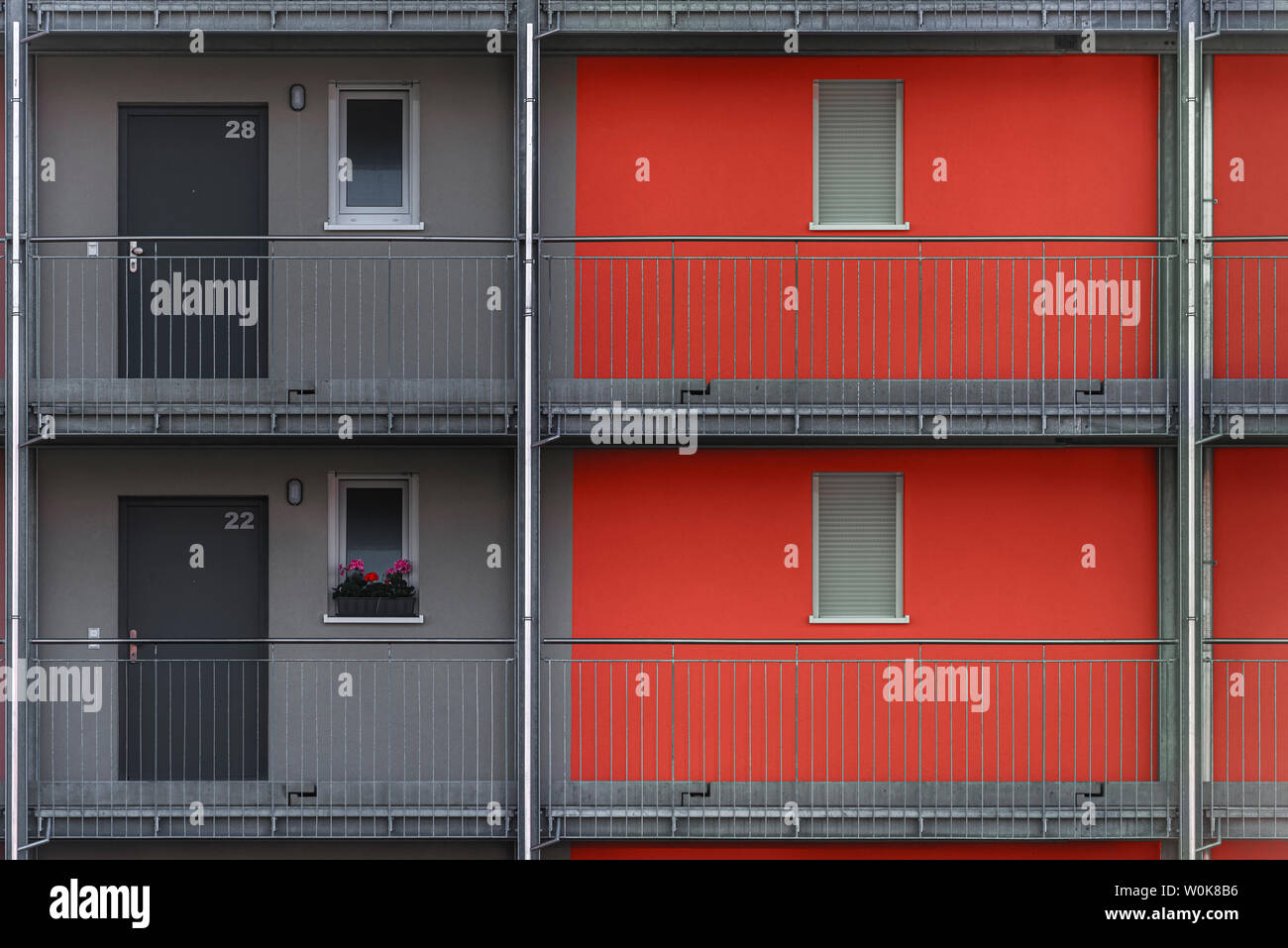 L'extérieur de deux étages d'un immeuble moderne avec des murs rouges et gris, sur une journée ensoleillée à Schwabisch Hall, en Allemagne. Banque D'Images