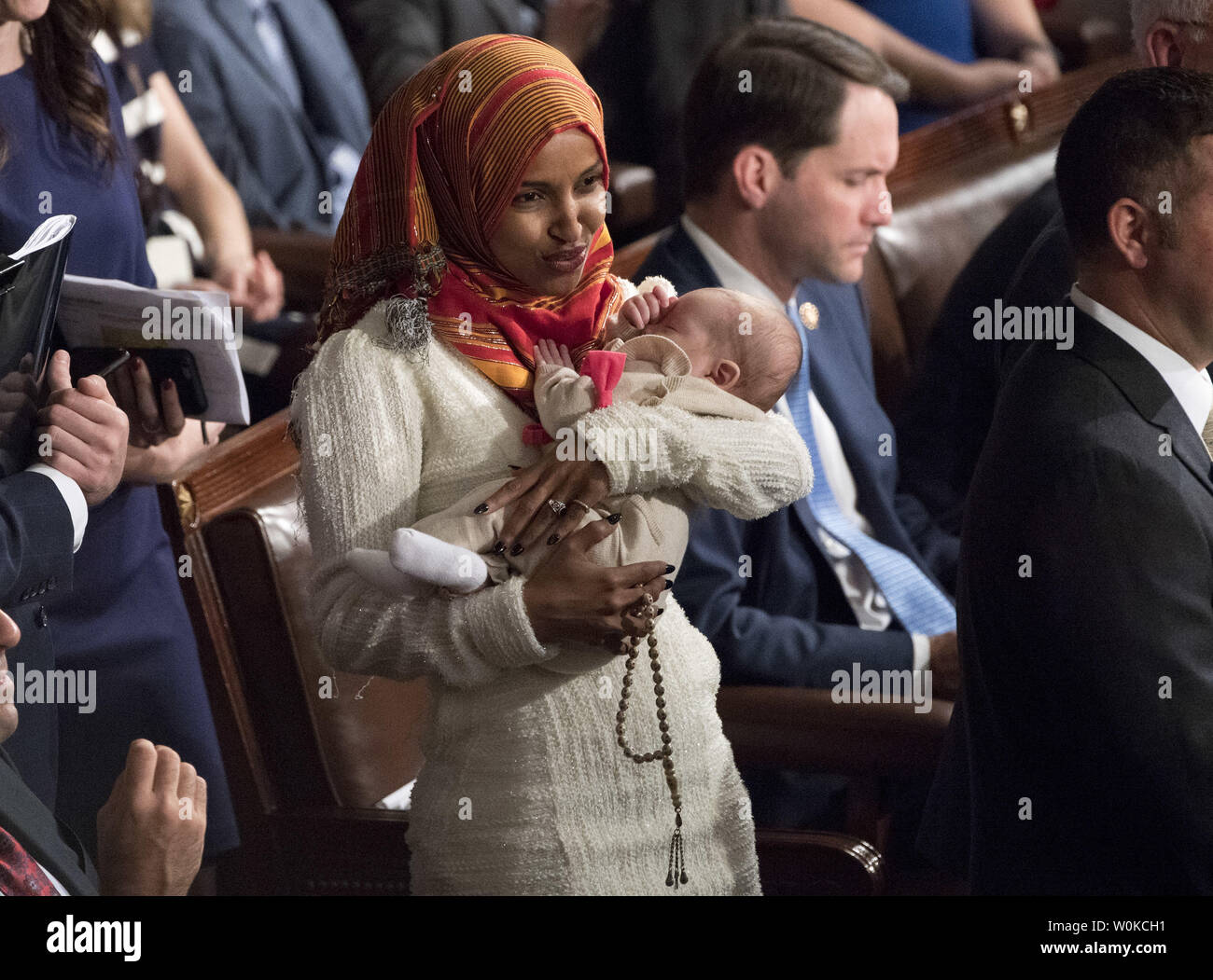 Ilhan Omar, D-MN, détient la Rép. Eric Swalwell bébé pendant le premier jour de la 116e Congrès, au Capitole à Washington, D.C. le 3 janvier 2019. Omar, un Somali American est la première personne à porter un hijab en congrès. Photo par Kevin Dietsch/UPI Banque D'Images