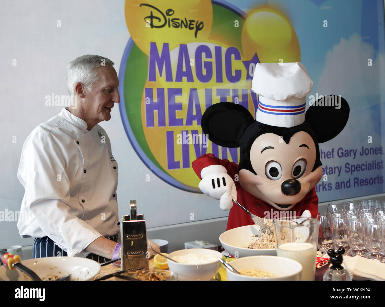 Le chef Gary Jones et le personnage de Walt Disney Mickey Mouse préparer une alimentation saine avant l'annonce de l'entreprise avancement important des lignes directrices sur la nutrition policy à Washington le 5 juin 2012. UPI/Yuri Gripas. Banque D'Images