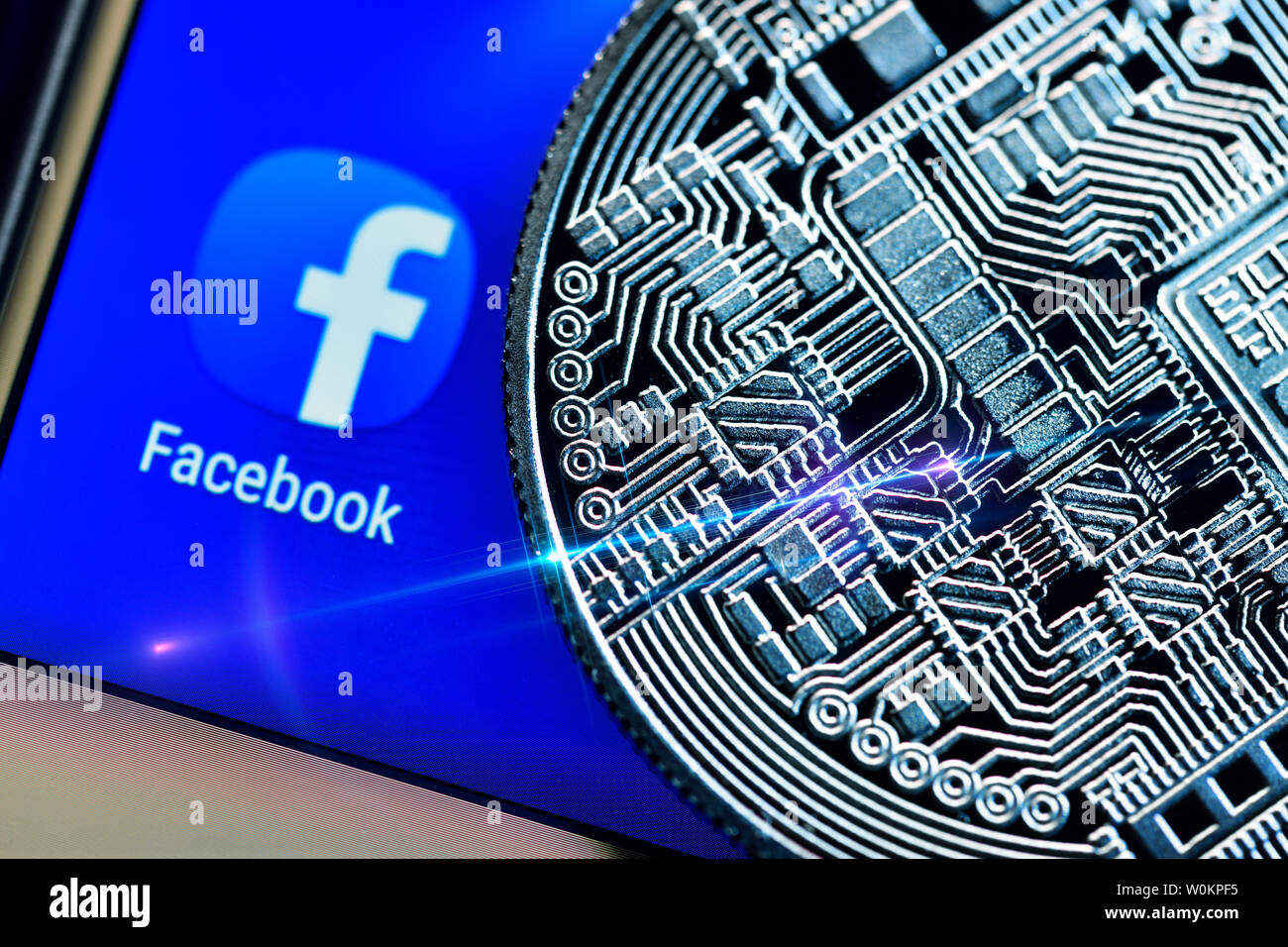 Application Facebook sur un écran de smartphone et de monnaie, la balance cryptocurrency Banque D'Images