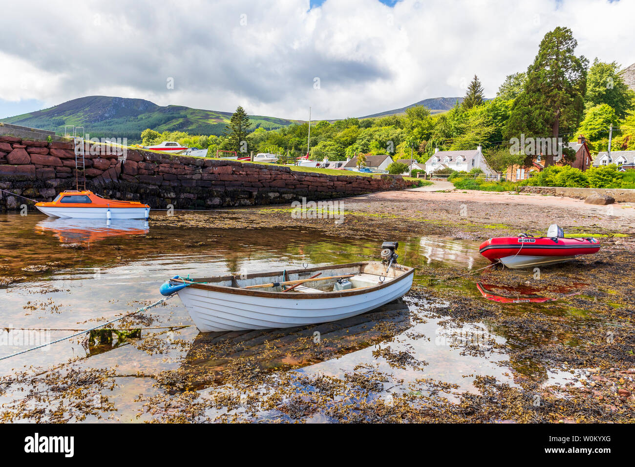 Petit port à Corrie sur l'île d'Arran, Firth of Clyde, en Écosse avec trois petits bateaux au bord de l'eau. Banque D'Images