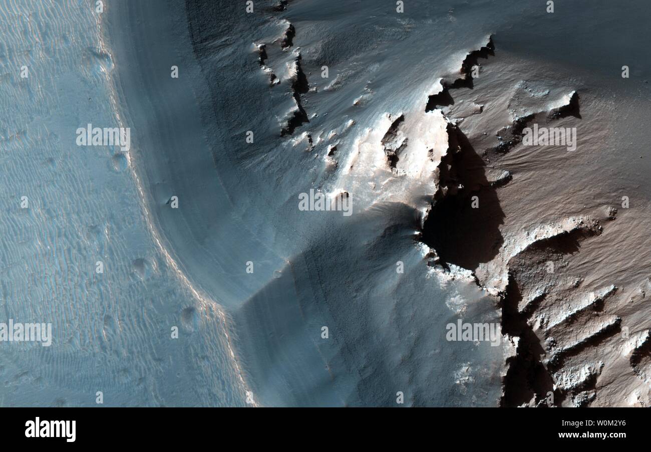 Cette image, acquise le 24 novembre 2015 par l'expérience scientifique d'imagerie haute résolution (HiRISE) à bord de l'appareil photo Mars Reconnaissance Orbiter de la NASA, montre le côté ouest d'une fosse allongée la dépression dans l'est de la région de Noctis Labyrinthus Mars. Le long de la paroi supérieure de la fosse est un dépôt en couches clair. UPI Banque D'Images