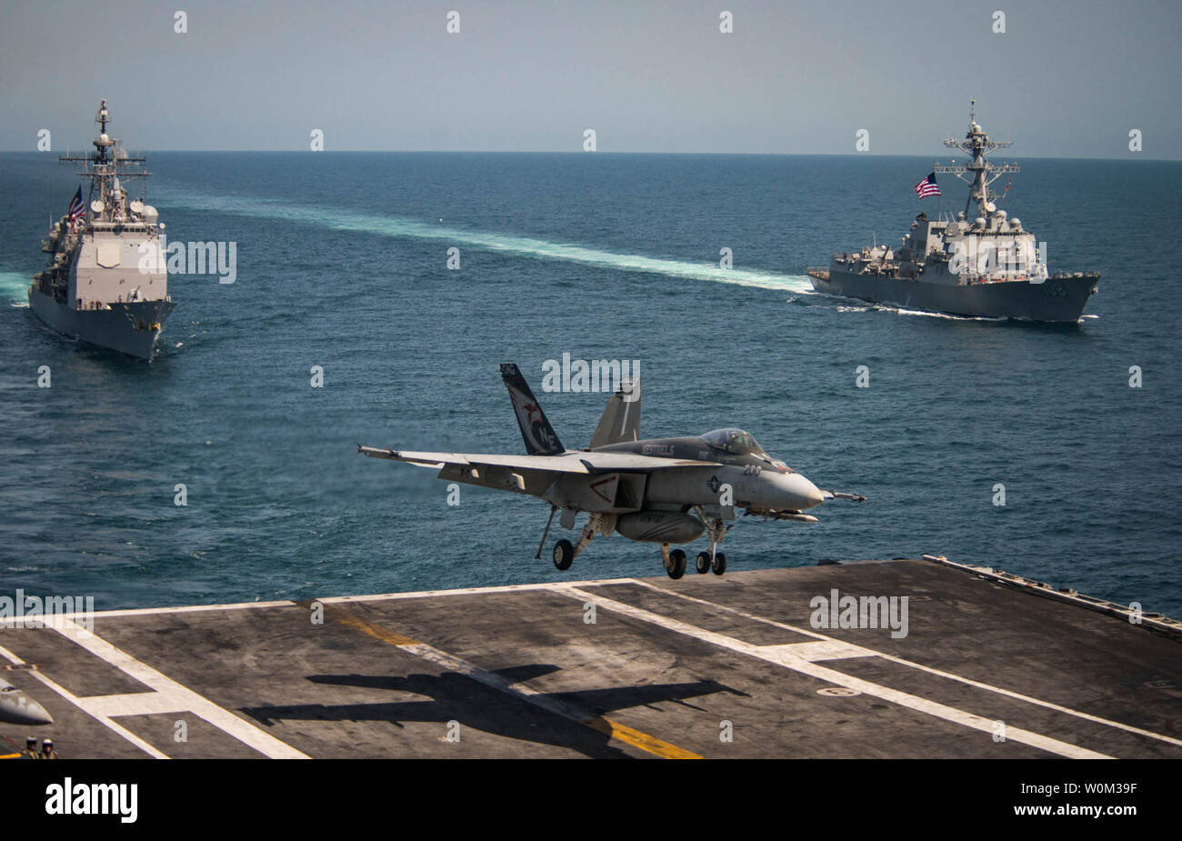 Un F/A-18E Super Hornet de la Crécerelle d' Escadron de chasse de grève (VFA) terres 137 le 3 mai 2017, dans le poste de pilotage de la classe Nimitz porte-avions USS Carl Vinson (CVN 70) comme la classe Ticonderoga croiseur lance-missiles USS Lake Champlain (CG 57), la gauche et la classe Arleigh Burke destroyer lance-missiles USS Wayne E. Meyer (DDG 108) transit l'ouest de l'océan Pacifique. La Marine américaine a patrouillé les Indo-Asia-Pacifique couramment pour plus de 70 ans la promotion de la paix et la sécurité régionales. Photo par MC2 Z.A. Landers/U.S. Navy/UPI Banque D'Images