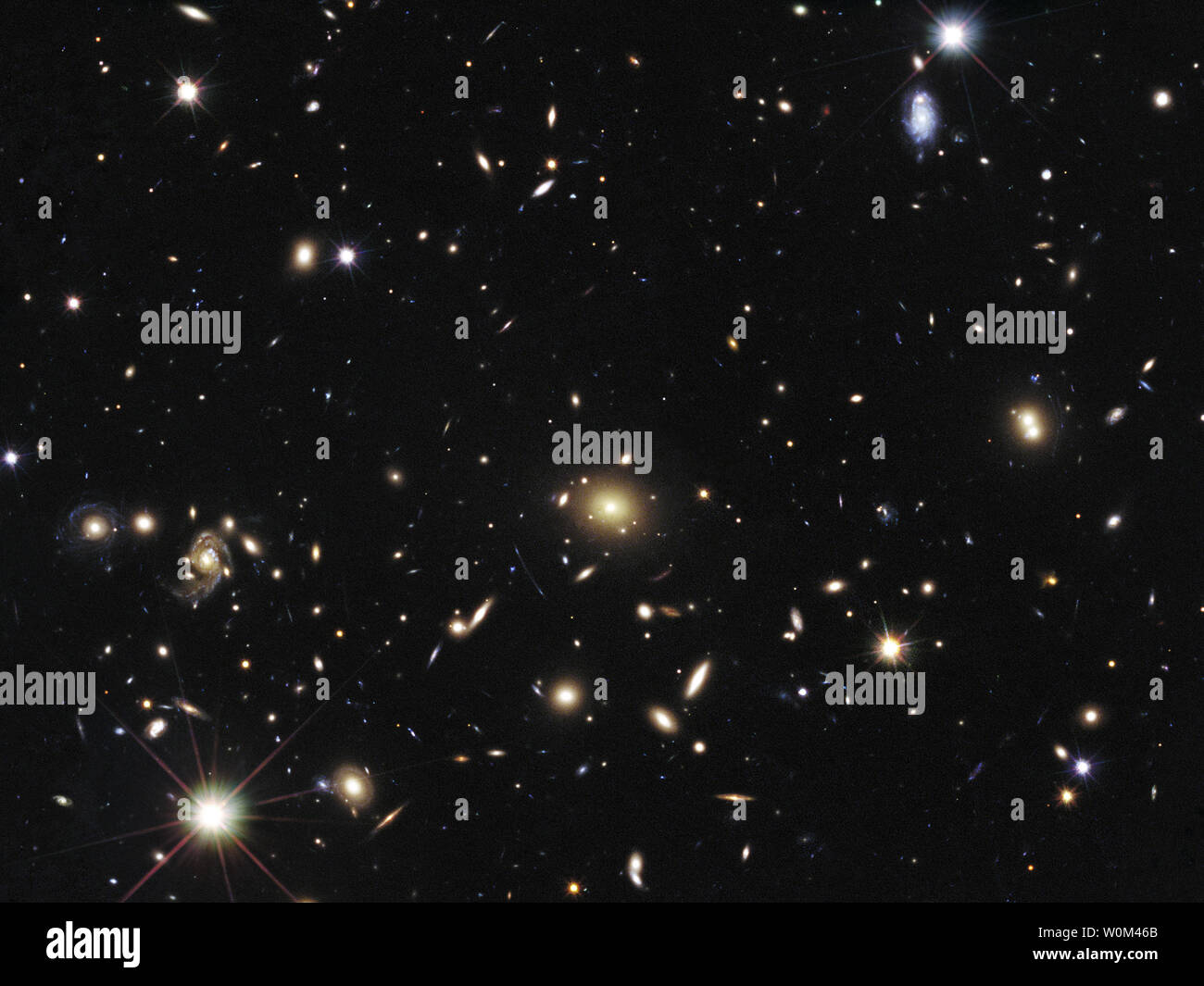 Le coeur d'un vaste amas de galaxies appelé MACSJ1720 +35 est vu dans cette image, prise dans le visible et le proche infrarouge par la NASA/ESA Hubble Space Telescope, et libérés le 1 mai 2014. L'amas est tellement massif que sa gravité déforme, il s'éclaire, et amplifie la lumière provenant d'objets plus éloignés derrière elle, un effet de lentille gravitationnelle. En haut à droite, l'explosion d'une étoile surnommé Caracalla et situé derrière le cluster peut seulement être établie. La supernova est membre d'une catégorie spéciale d'explosion d'une étoile appelée Type Ia, prisé par les astronomes car il fournit un composé Banque D'Images