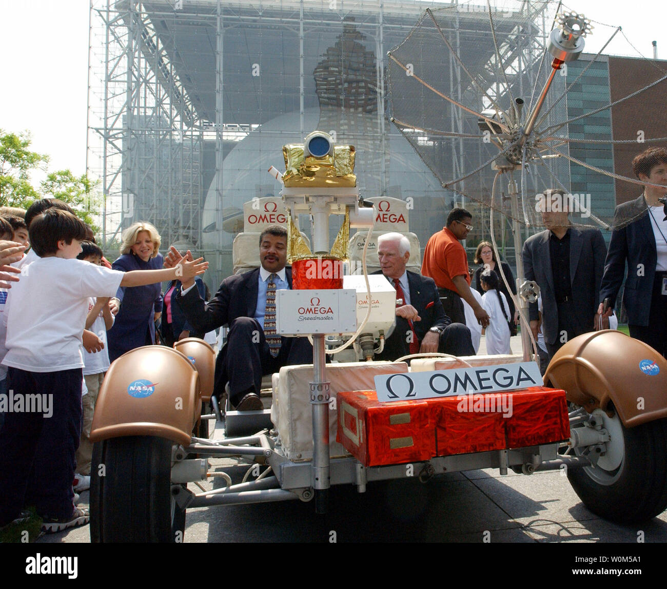 L'astronaute Gene Cernan, le dernier homme à marcher sur la lune, à droite, et le Dr Neil Tyson, Directeur de l'Hayden Planétarium, de manœuvrer Le Rover lunaire Omega dans tout le Rose Center's Ross exposée à New York City le vendredi 7 mai 2004, tandis que la ville de New York 2e et 3e année les encourager à aider à lancer SpaceFest. SpaceFest est un trois-week-end-longue série de programmes publics offrant des activités spatiales et d'événements pour les familles dans le Rose Center for Earth and Sciences. Photo UPI/Maurizio Bacci Banque D'Images