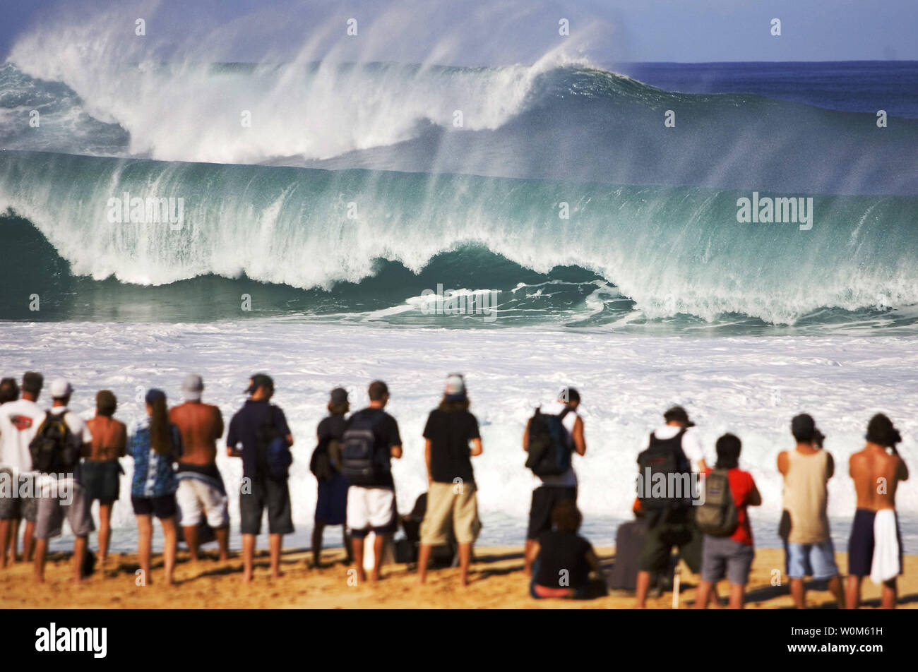 Spectateurs watch vagues gigantesques crash à la lieu de la Rip Curl Pro Pipeline masters à l'Banzai pipeline sur la côte nord d'Oahu, Hawaii le 13 décembre 2004.. Le concours a été mis en attente en raison de conditions de surf de tempête qui a frappé la Côte-Nord. Le Rip Curl Pipeline masters est l'événement final pour les hommes sur la 2004 favorise l'ASP World Championship Tour et offre le top 45 surfeurs et trois wild card entrants. (Photo Pierre Tostee/UPI/ASP Tostee) Banque D'Images