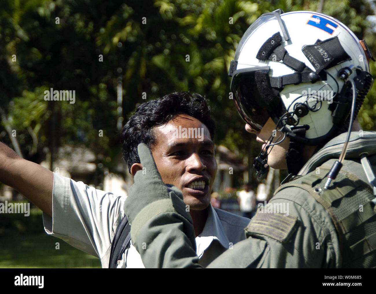 Les systèmes de guerre Aviation 2e classe opérateur Justin Garrett de Burbank, Californie, des entretiens avec un représentant local dans la ville de Lamno, Sumatra sur ce que l'aide de secours est nécessaire le 7 janvier 2005. Porte-hélicoptères affectés à deux de l'Escadre aérienne (CVW-2) et les marins de l'USS ABRAHAM LINCOLN (CVN 72) appuient l'opération Unified Assistance, l'opération humanitaire d'efforts à la suite du tsunami qui a frappé l'Asie du Sud Est. (Photo d'UPI/Seth C. Peterson/US Navy) Banque D'Images