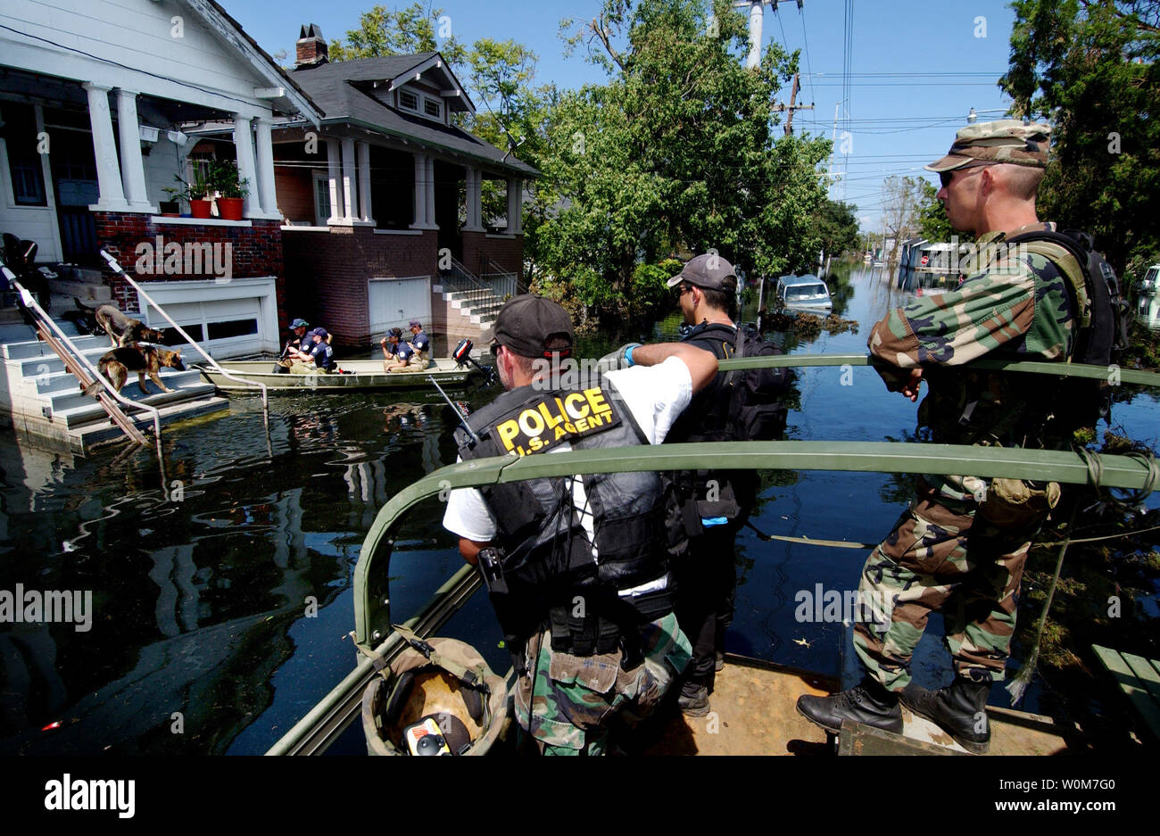 Les membres de la Garde nationale de l'Armée de l'Oklahoma et les agents de la Drug Enforcement Agency attendez que la SPCA d'enlever deux chiens avant de vérifier une maison à la Nouvelle Orléans pour les résidents, 7 septembre 2005. Les militaires et les agences fédérales s'effectuer perquisitions maison par maison sauvetage d'habitants de La Nouvelle-Orléans coincés dans leur maison à cause des inondations causées par l'ouragan Katrina. (Photo d'UPI/Scott Reed/Air Force) Banque D'Images