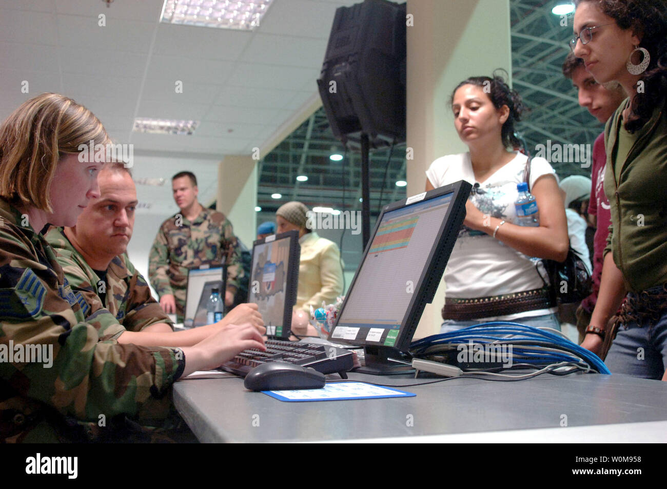 U.S Air Force Staff Sergeant Angela clair (à gauche), les services de police, 39e Escadron des Forces de sécurité, les intrants badge de sécurité des données dans le système avant d'émettre à des citoyens américains au Liban, au cours de la transformation à la 39e Escadron de préparation logistique du déploiement du centre de traitement de Incirlik Air Base, Turquie le vendredi, Juillet 21, 2006. (Photo d'UPI/Larry E. Reid Jr./USAF) Banque D'Images