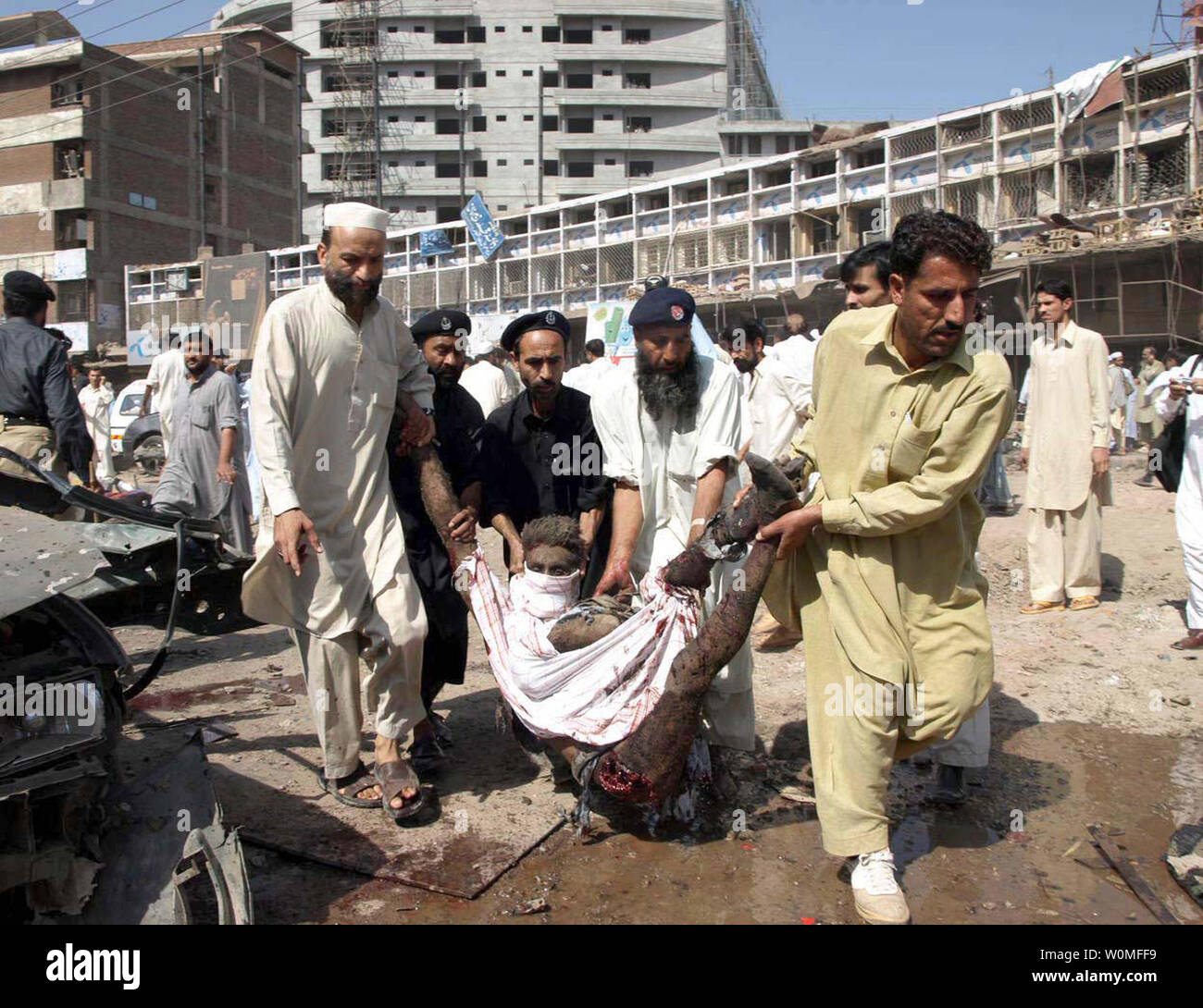 Des volontaires pakistanais transporter un blessé victime d'un attentat-suicide à la bombe à Peshawar site le 9 octobre 2009. Les véhicules de kamikazes se remplie d'explosifs, tuant 48 personnes dans une zone encombrée près des banques, des magasins et une salle de mariage heures après une attaque similaire à l'extérieur d'un poste de police à Bannu. UPI/Fahim Ahmed Banque D'Images