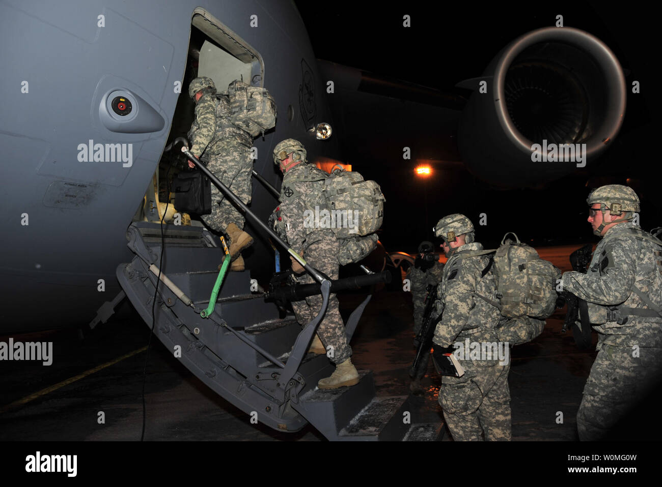 Un groupe de soldats de la Compagnie Charlie, 2e Bataillon, 22e Régiment d'infanterie de la 10e Mountain Division's 1st Brigade Combat Team, bord d'un avion de transport C-17 à partir Fort Drum, New York, pour l'Afghanistan, le 9 janvier. Deuce 'Triple' est le premier de six bataillons de la 1ère BCT que sont le déploiement de troupes à l'augmentation de l'appui de l'opération Enduring Freedom. UPI/John Reine/U.S. Army Banque D'Images
