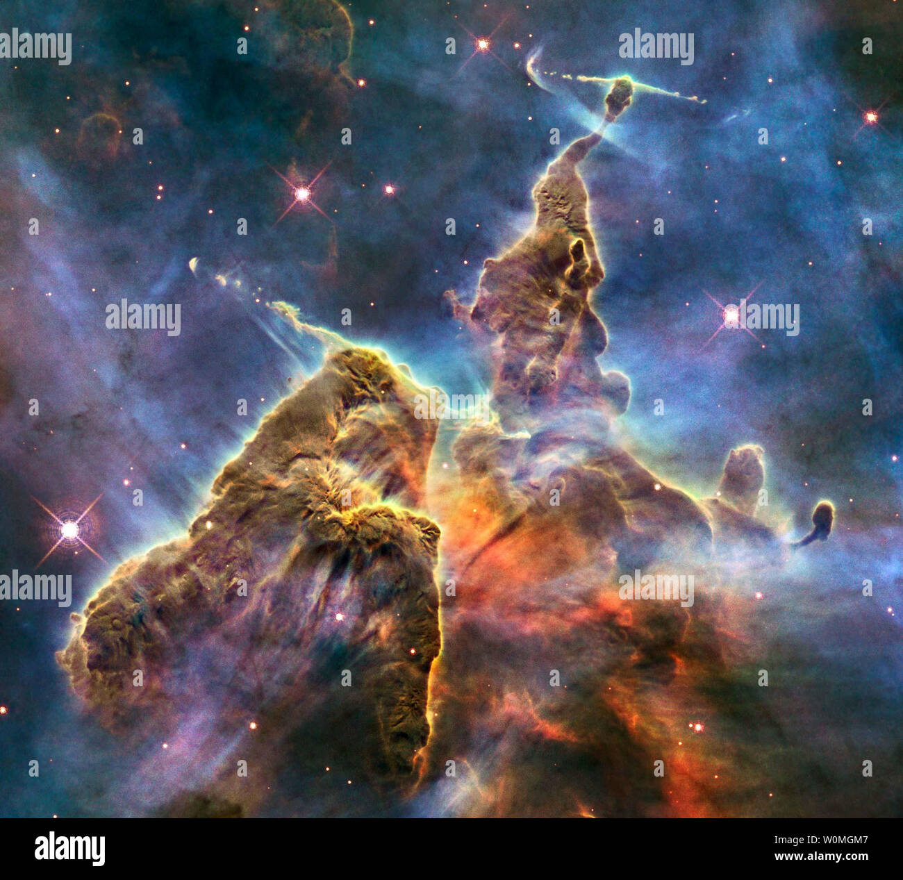 Ce nouveau télescope spatial Hubble photo libérée par la NASA montre une partie de l'un des plus grands vu la naissance d'étoiles dans les régions de la galaxie, la nébuleuse Carina. Tours de l'hydrogène froid lacé avec augmentation de la poussière de la paroi de la nébuleuse. Capturé ici sont le sommet d'un trois-année-lumière-grand pilier de gaz et la poussière qui s'est rongé par la lumière brillante des étoiles brillantes. Le pilier est également mis à part de l'intérieur, comme l'enfant étoile enfoui à l'intérieur il fire off des jets de gaz qui peut être vu de streaming pics imposants comme à flèches dans l'air. UPI/NASA Banque D'Images