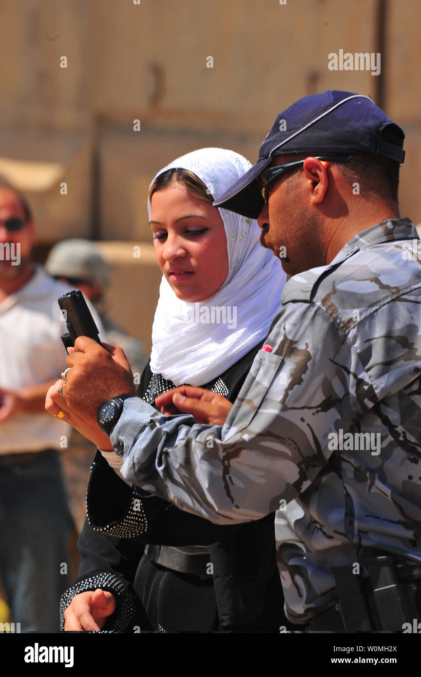 Un soldat de l'armée iraquienne enseigne une femme police irakienne recruter comment effacer son arme sur une plage près de Mossoul, en Irak, le 9 juillet 2010. Des soldats américains avec le 855th Compagnie de Police Militaire 317e Bataillon de la Police Militaire, 49e Brigade de police militaire, attaché à la 3e Division d'infanterie, et les soldats iraquiens ont aidé à former les recrues. UPI/Edward Reagan/US Army Banque D'Images