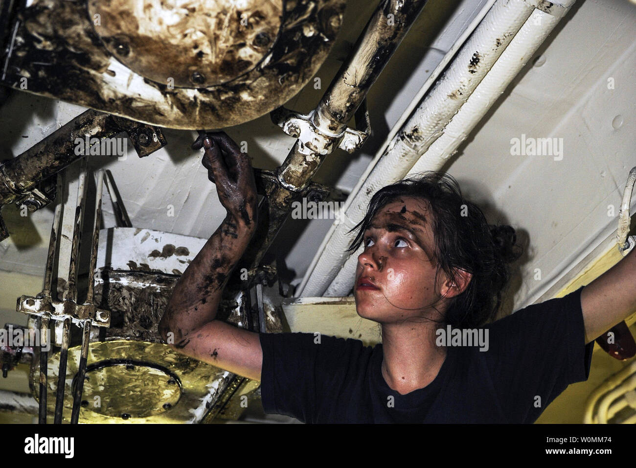 La Marine américaine, le Maître de 3e classe Amanda Coak installe une poulie rotative pour couvrir 2 catapulte à bord des porte-avions USS Nimitz pendant qu'ils sont en cours dans la région du Golfe, le 5 juillet 2013. Le Groupe grève Nimitz est déployé sur le 5e Flotte des États-Unis zone de responsabilité pour mener des opérations de sécurité maritime, les efforts de coopération en matière de sécurité dans le théâtre et missions d'appui pour l'opération Enduring Freedom. .UPI/ C. Bartlett /DOD Banque D'Images