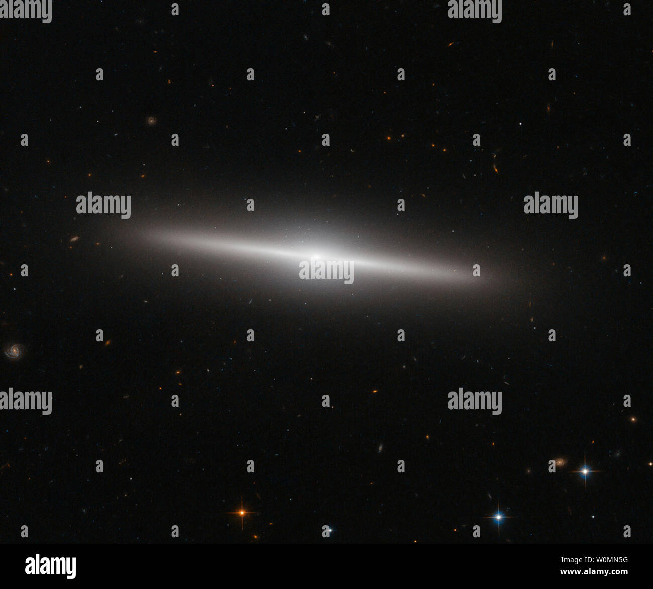 Ce document non daté NASA/ESA Hubble Space Telescope image montre la galaxie IC 335 en face d'une toile de galaxies lointaines. IC 335 fait partie d'un groupe de galaxies contenant trois autres galaxies, et situé dans l'amas de galaxies Fornax 60 millions d'années-lumière, le 30 décembre 2014. Comme le montre cette image, le disque de IC 335 apparaît de côté du point de vue de la Terre. UPI/NASA Banque D'Images