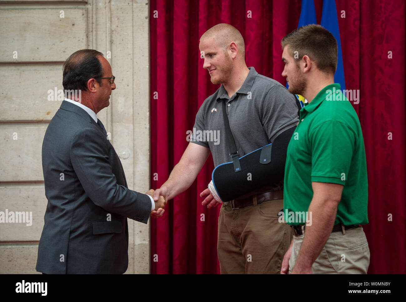 1ère classe pilote américain Spencer Stone, serre la main du Président français François Hollande après avoir reçu la Légion d'honneur à son domicile à Paris le 24 août 2015, à la suite d'une attaque terroriste manquée sur un train français. Pierre était en vacances avec ses amis d'enfance, Aleksander Skarlatos et Anthony Sadler, lorsqu'un homme armé a saisi son train transportant un fusil d'assaut, un revolver et un couteau polyvalent. Les trois amis, avec l'aide d'un passager britannique, lumières le tireur après son fusil coincé. Les quatre hommes étaient au courant de la Légion d'honneur pour leur bravoure. U.S. Air Force Photo/Ryan grue/UPI Banque D'Images