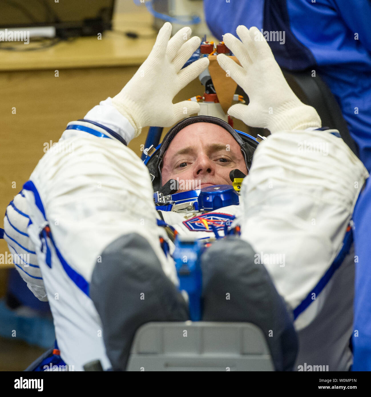 Expedition 43 L'astronaute de la NASA Scott Kelly attend que sa combinaison spatiale des gants pour être mis sur que lui et ses collègues membres de l'équipage, de cosmonautes russes Gennadi Padalka et Mikhail Kornienko de l'Agence spatiale fédérale russe (Roskosmos) ont leurs combinaisons sokol russe vérifier la pression avant leur lancement à bord du vaisseau Soyouz TMA-16M à la Station spatiale internationale le 27 mars 2015 dans Baikonor, au Kazakhstan. ..Une partie de la NASA en matière de programme de recherche, la Mission d'un an sur la Station spatiale internationale est un effort conjoint de l'agence spatiale américaine, l'Agence spatiale fédérale russe (Roscosmo Banque D'Images