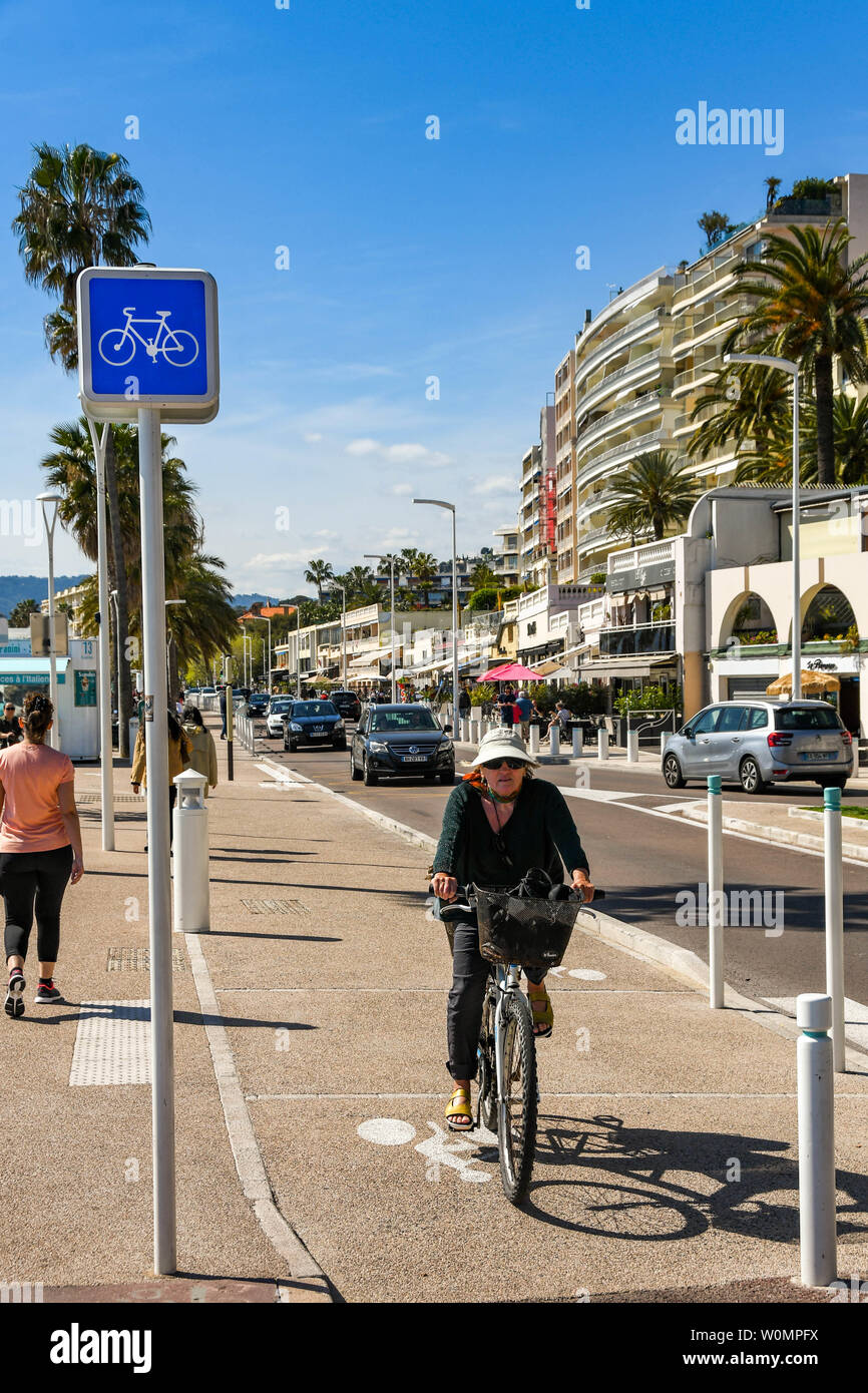 CANNES, FRANCE - Avril 2019 : Personne à vélo sur une voie cyclable le long d'une route sur la promenade à Cannes Banque D'Images