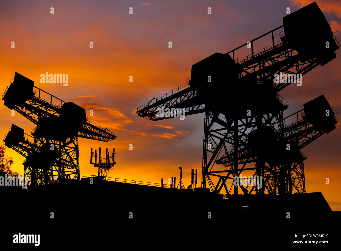 Silhouette, de navires, de chantier, grues, silhouetté,,contre,coucher de soleil,téléphone mobile,antenne,toit,,top,téléphone,mât,échanger,communications, Banque D'Images