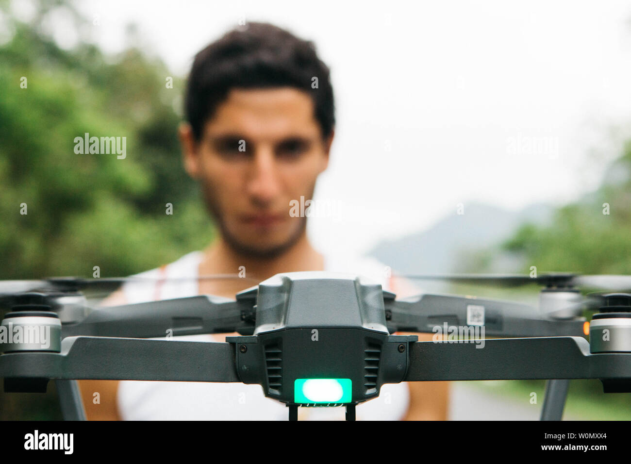 Close up flying dron en face d'un homme concentré floue pour le contrôler d'apprentissage Banque D'Images